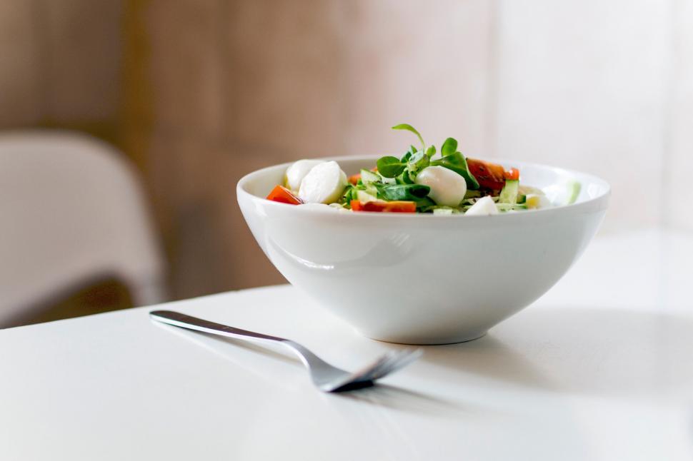 Free Image of Fresh bowl of salad on a clean white table 