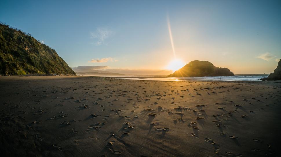 Free Image of Sunrise over a serene sandy beach 