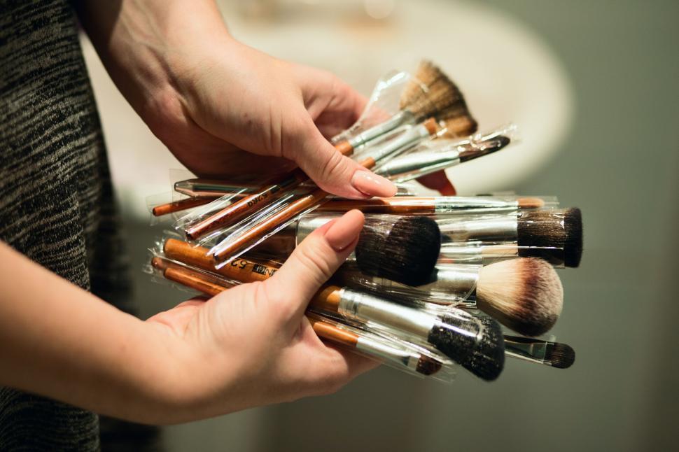 Free Image of Hands holding a variety of makeup brushes 