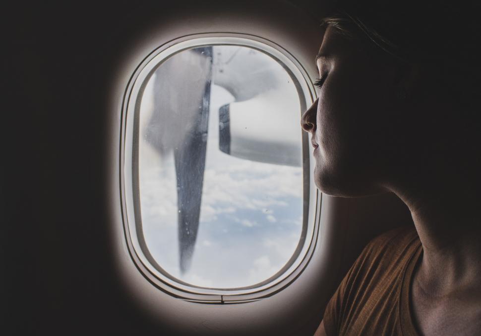 Free Image of Woman looking out airplane window 