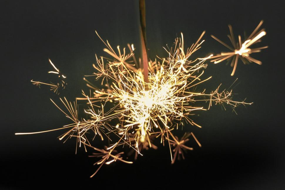 Free Image of Vivid sparkler igniting the dark with bright sparks 