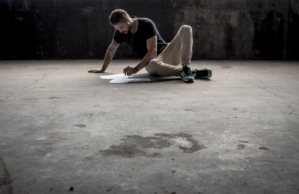 Free Image of Artist drawing on floor in empty room 