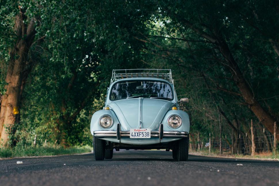 Free Image of Vintage blue car parked on an empty road 