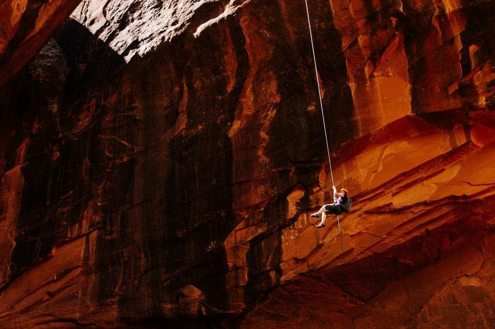 Free Image of Climber descending a rope in a canyon 