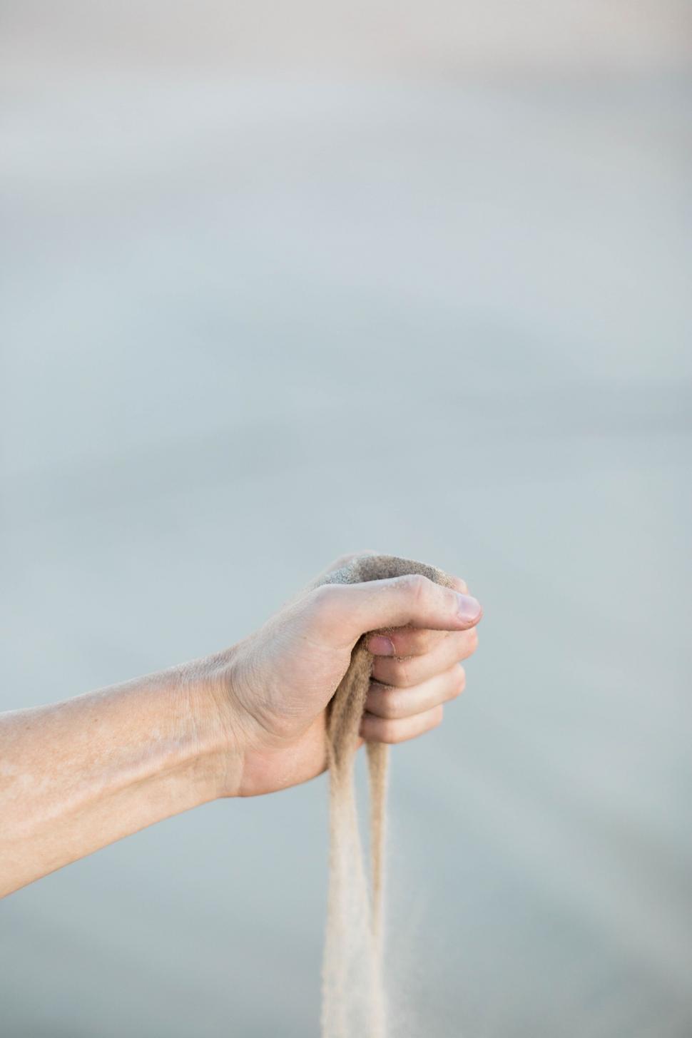 Free Image of Hand gripping a rope on a sandy background 