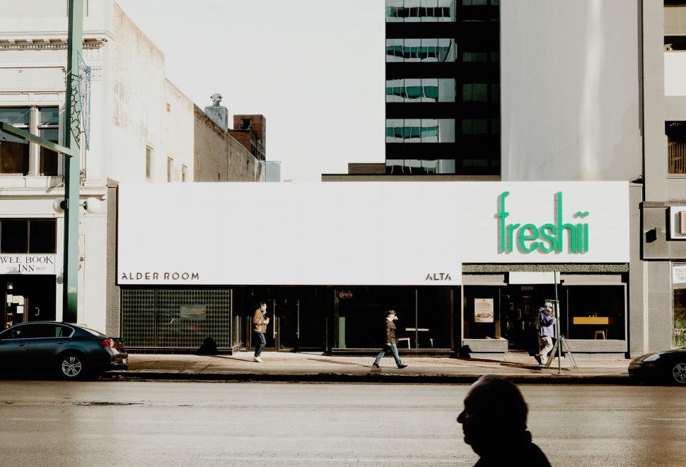 Free Image of Urban storefront with people walking past 