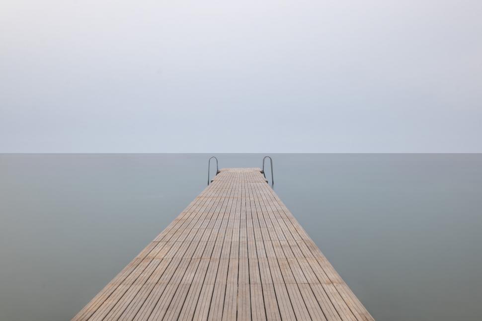 Free Image of Wooden pier extending into calm sea 