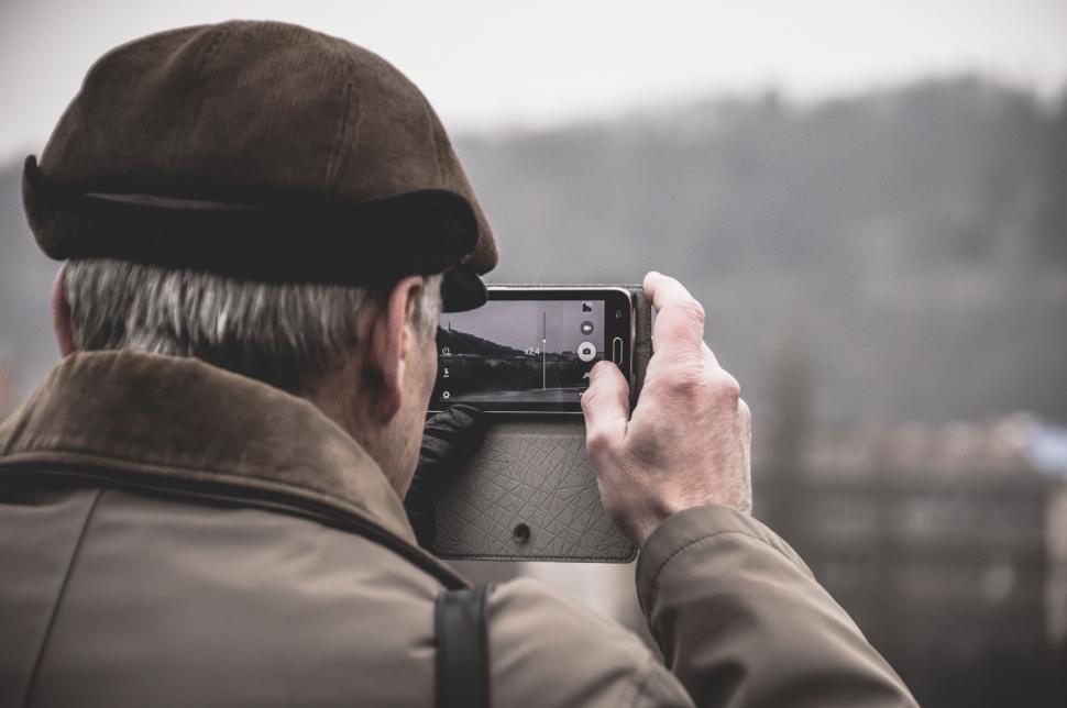 Free Image of Man capturing a photo with smartphone 