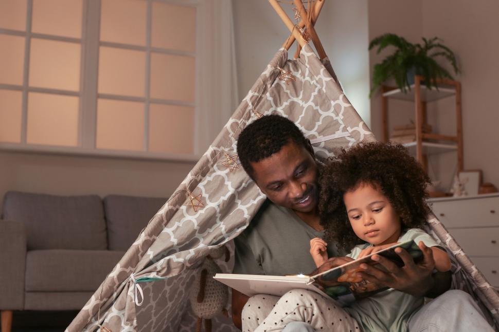 Free Image of Father and child reading in teepee 