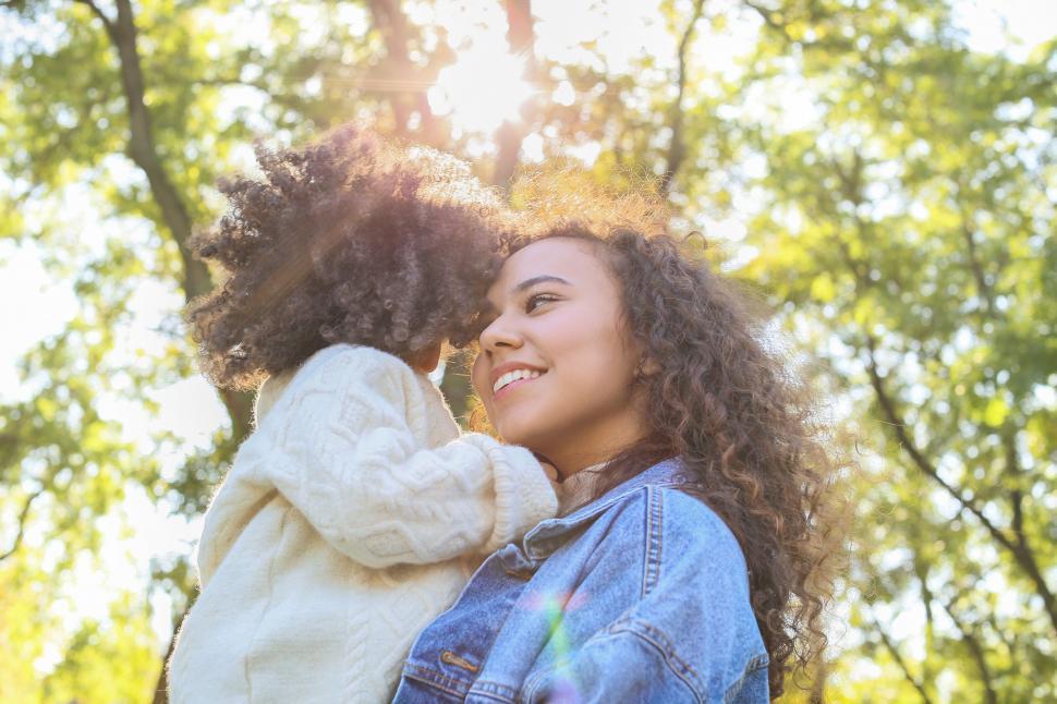 Free Image of Mother and daughter embracing in sunlight 