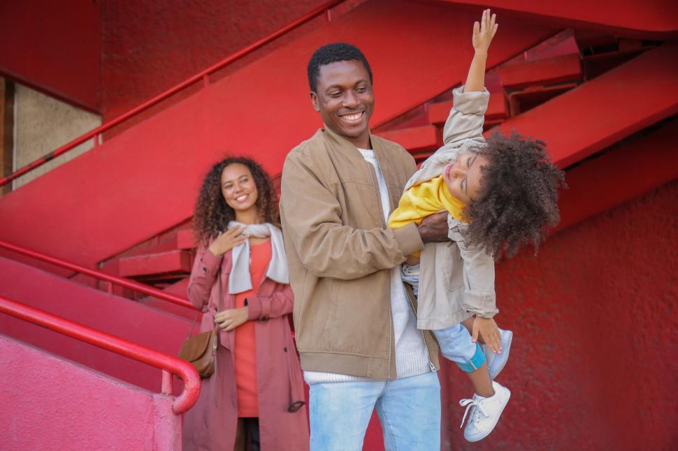 Free Image of Family posing in front of a red staircase 