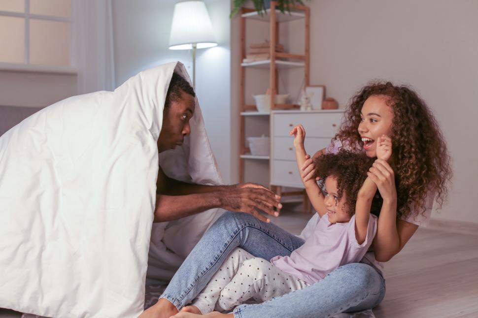 Free Image of Indoor playful family moment under blanket 