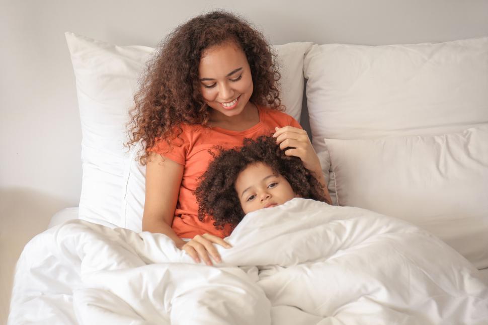 Free Image of Mother cuddling with daughter in bed 