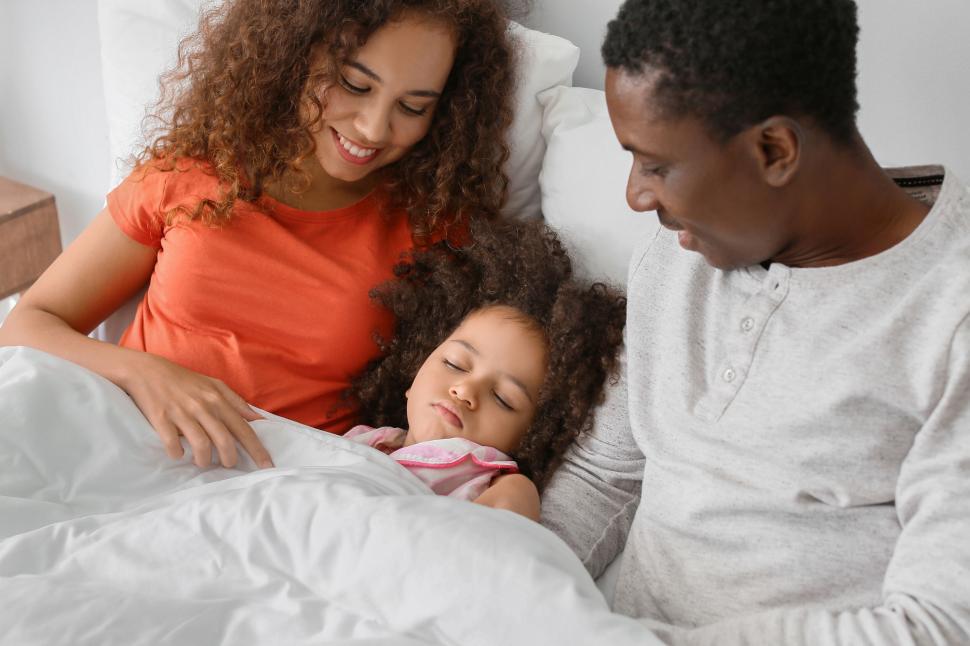 Free Image of Family with child in bed cuddling 