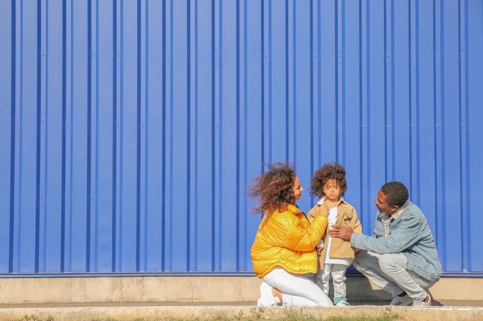 Free Image of Family conversation against a blue wall backdrop 