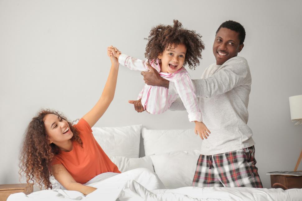 Free Image of Family playing together on a bed 