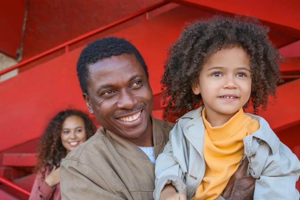 Free Image of Family of three with striking red backdrop 