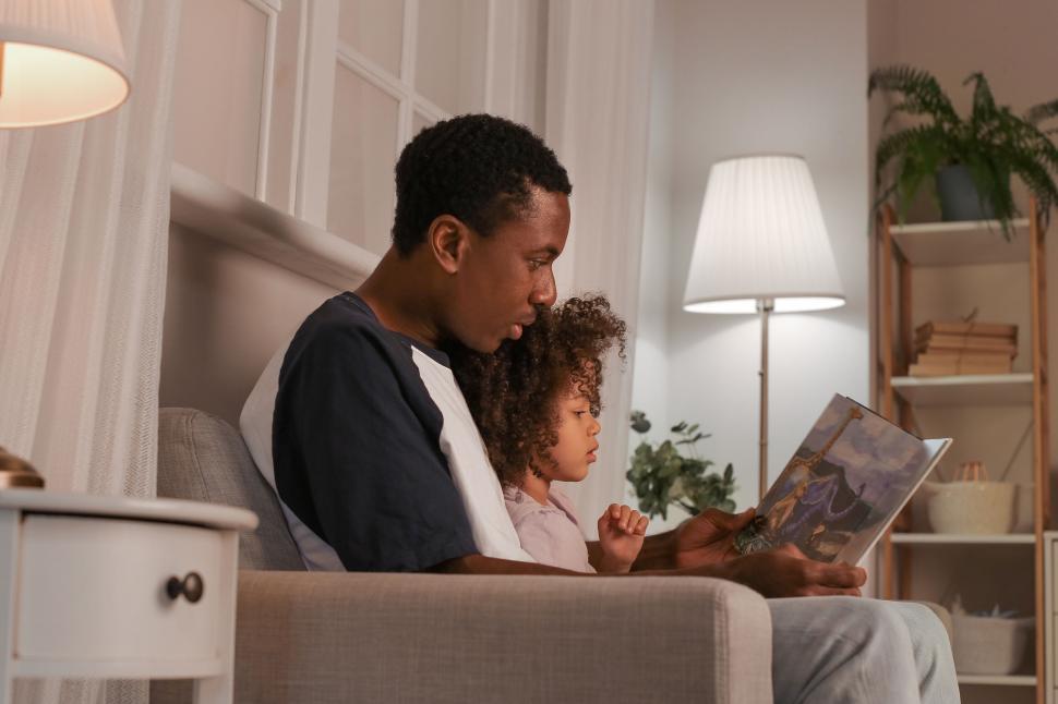 Free Image of Father and daughter enjoying reading a book 