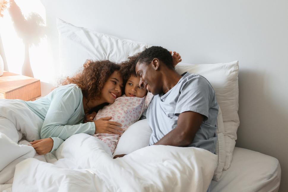 Free Image of Family cuddling in bed together 
