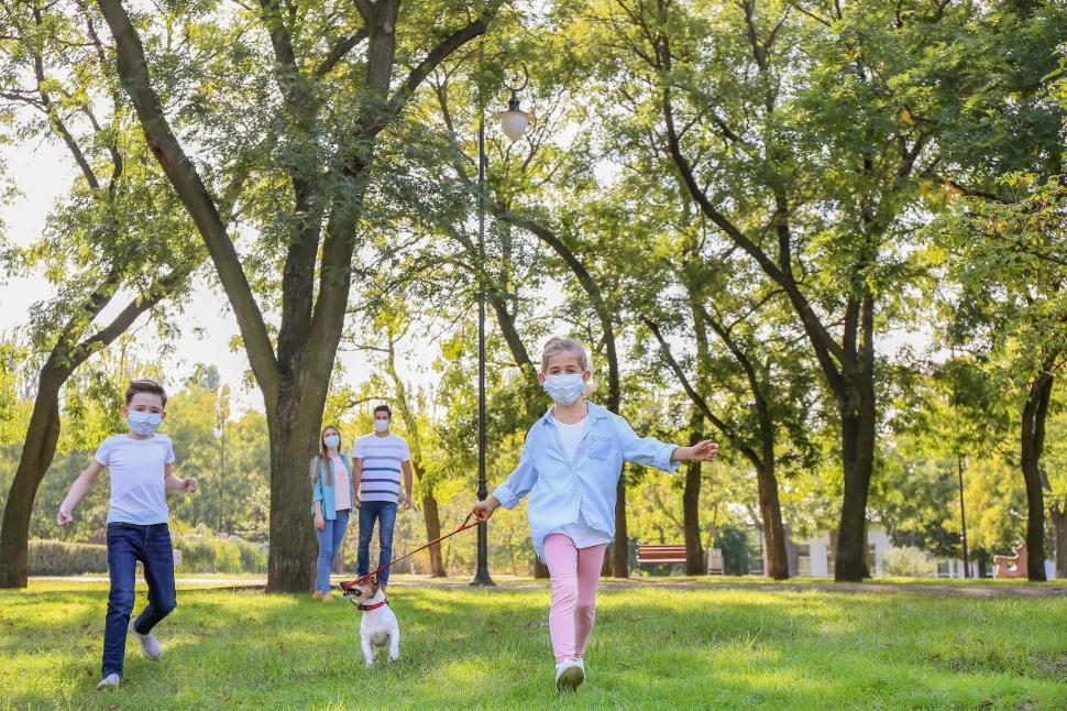 Free Image of Family and dog walking on path in green park 