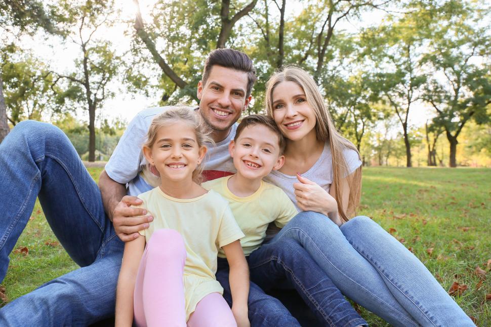 Free Image of Family sitting together on grass in a park 