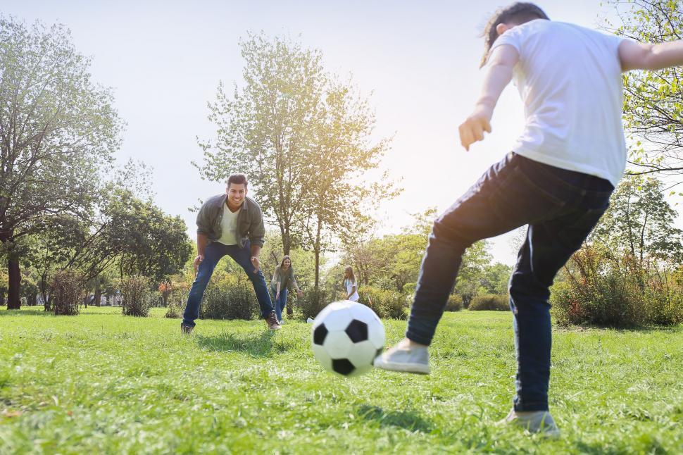 Free Image of Family playing soccer together in park 