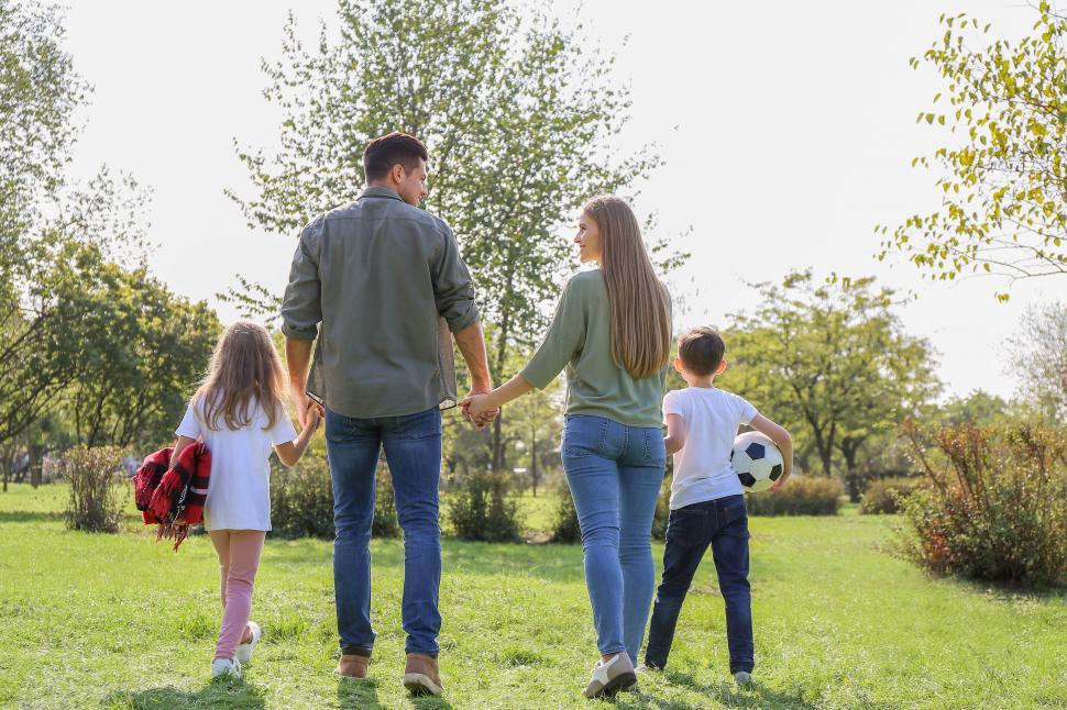Free Image of Family holding hands walking in the park 