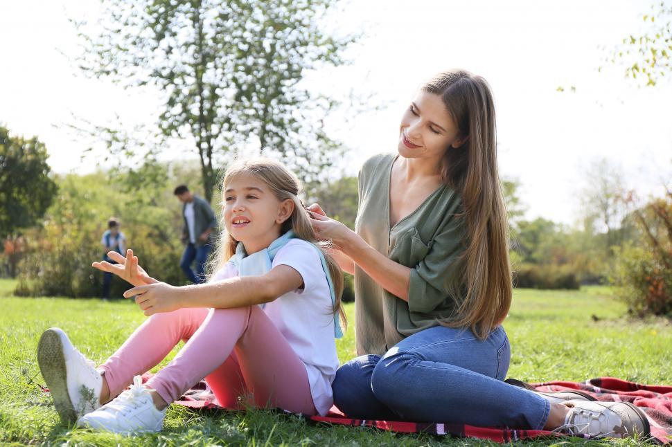 Free Image of Mother and daughter relaxing on park grass 