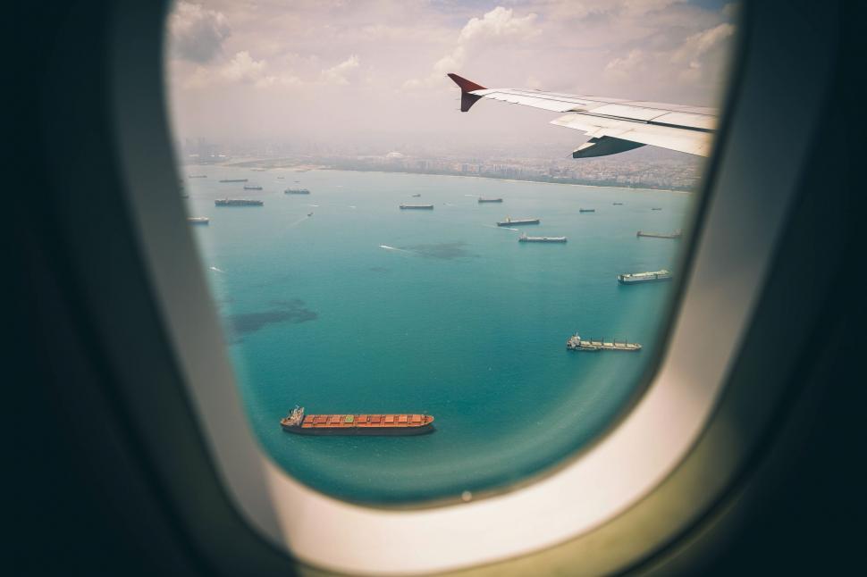 Free Image of Airplane wing with a view of ocean and ships 