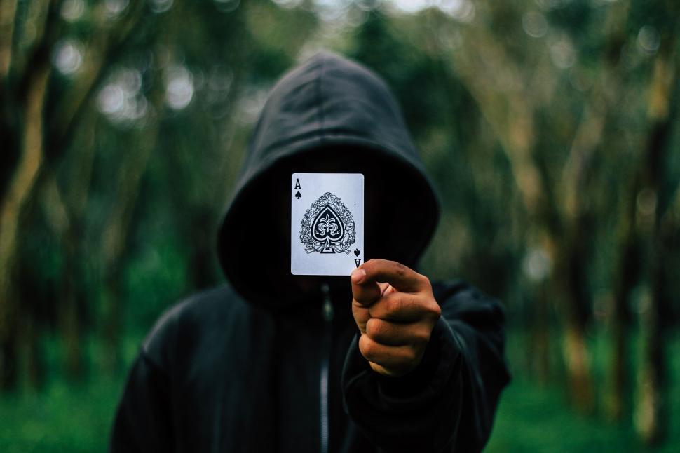 Free Image of Mysterious figure holding ace card 