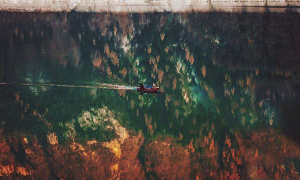 Free Image of Boat gliding on a reflective autumn lake 