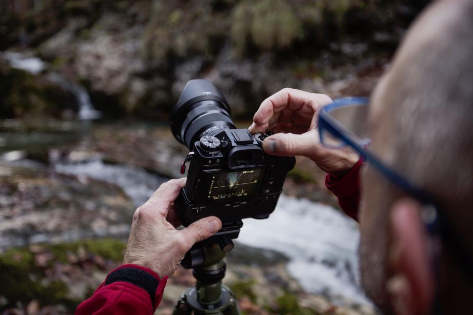 Free Image of Photographer capturing a waterfall in the forest 