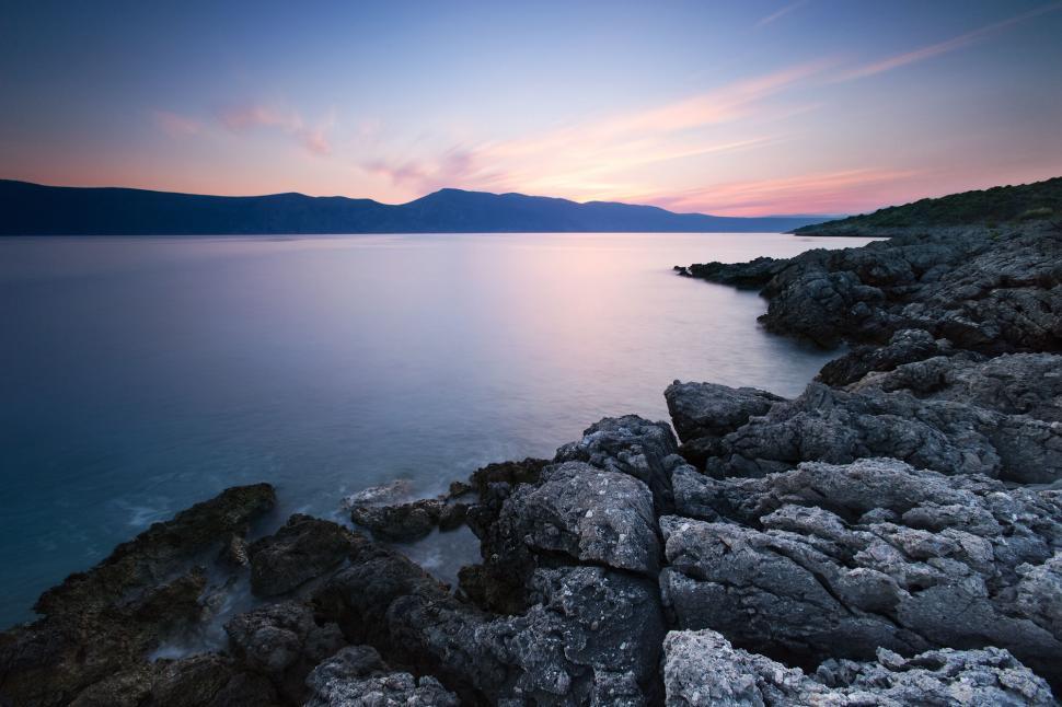 Free Image of Serene seaside sunset with rocky foreground 