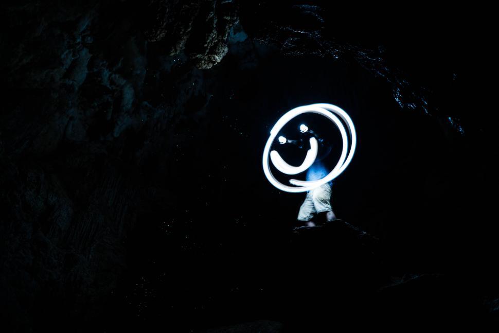 Free Image of Person creating light circle in a cave 