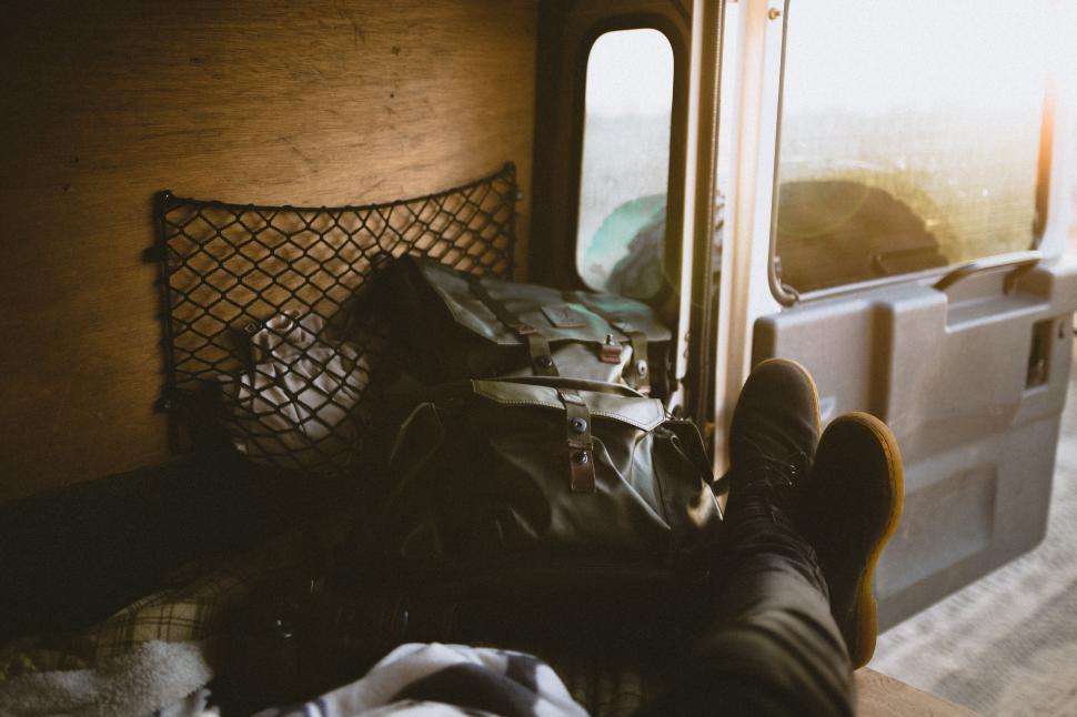 Free Image of Traveler s feet and backpack in a vintage van 