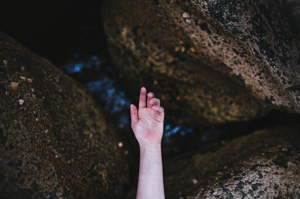 Free Image of Arm reaching out between boulders 