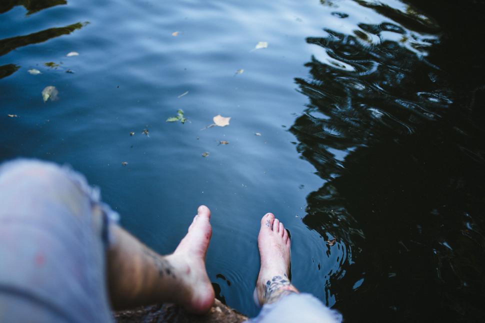 Free Image of Bare feet dangling above water 