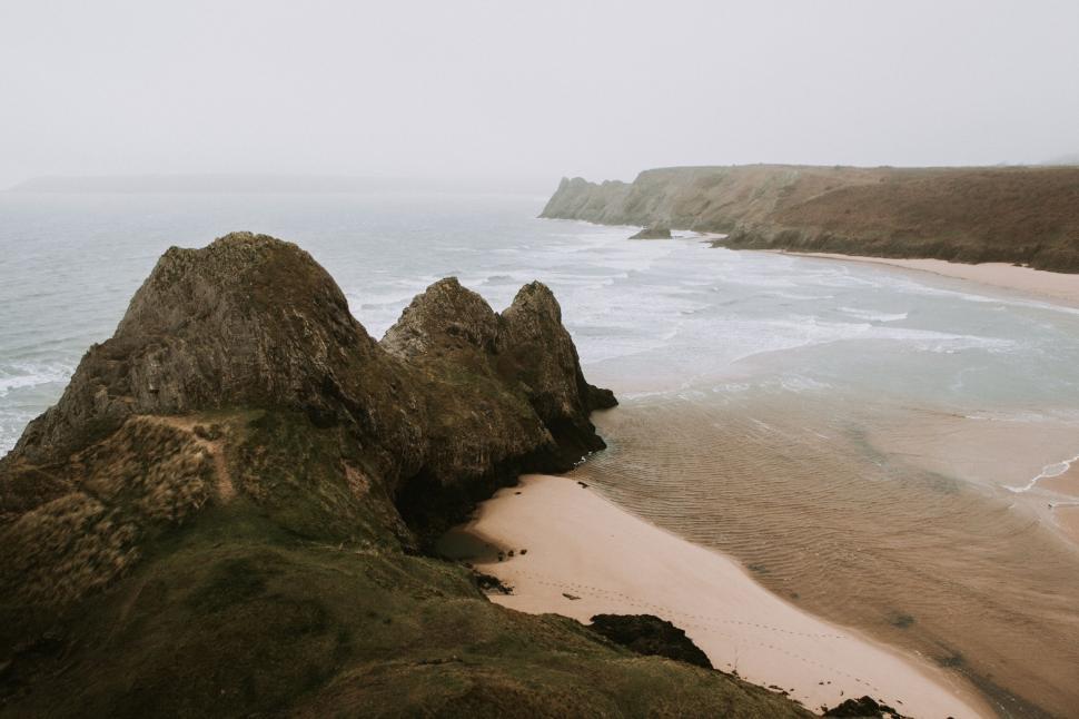 Free Image of Cliffs and beach along the rugged coastline 
