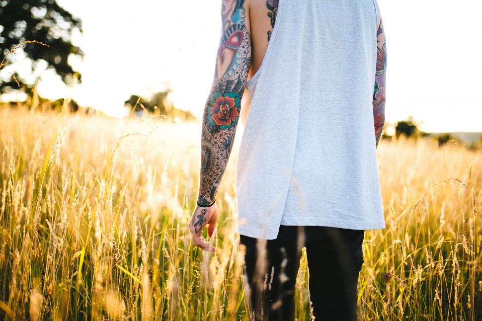 Free Image of Close-up of tattooed arm in a field 