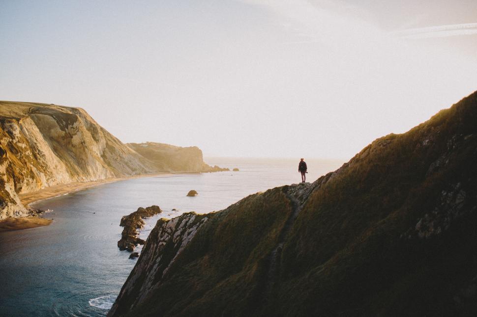 Free Image of Solitary figure overlooking ocean cliffs 