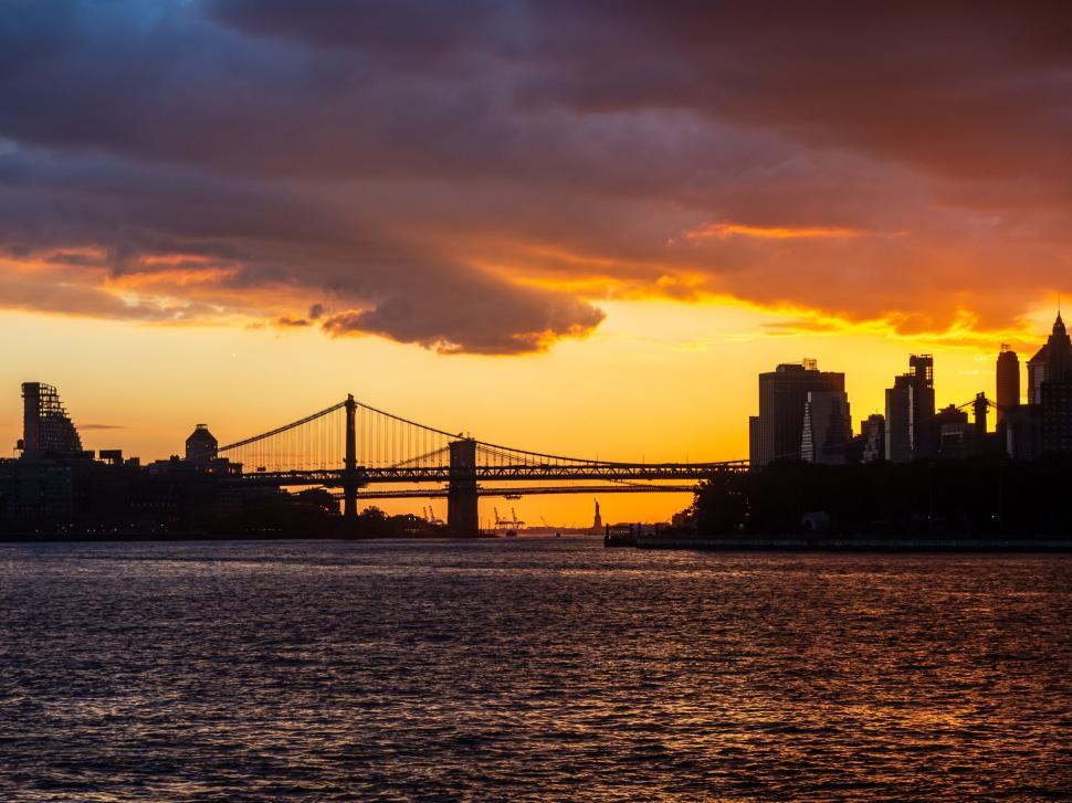 Free Image of Sunset silhouette of a city skyline with bridge 