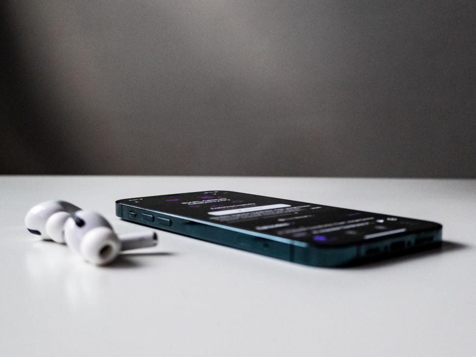 Free Image of Smartphone and earphones on grey surface 