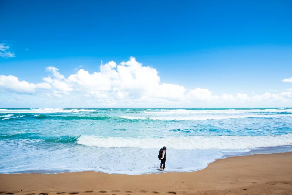 Free Image of Person walking alone on a sunny beach 