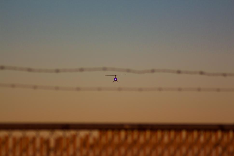 Free Image of Faintly glowing drone flying at dusk 