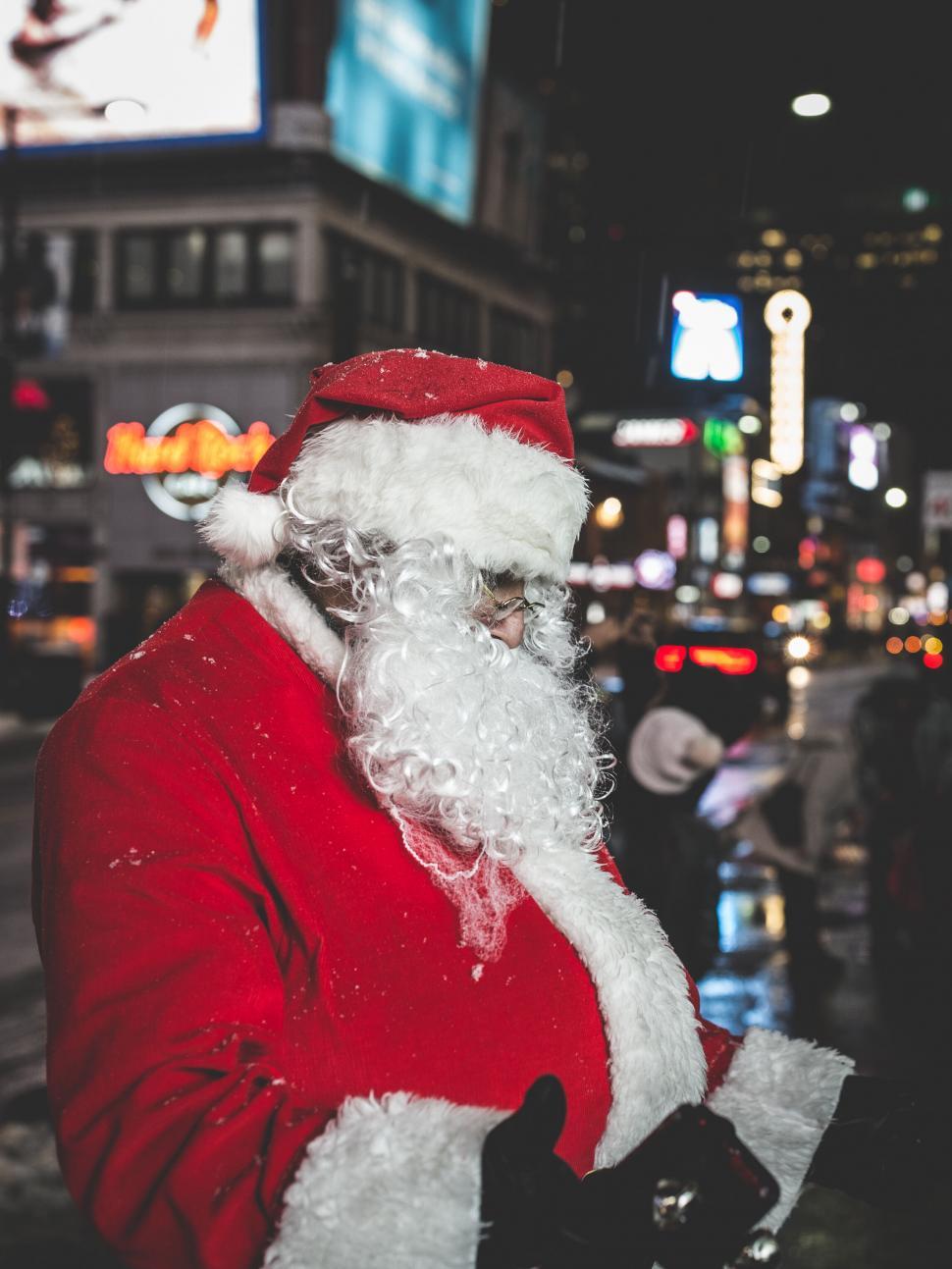 Free Image of Santa Claus in busy city night 