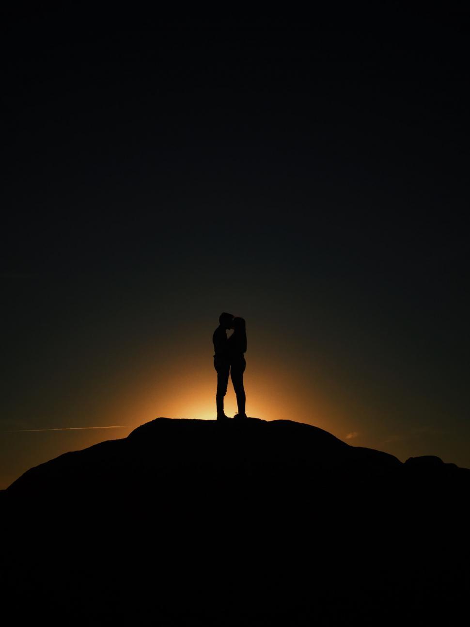 Free Image of Silhouette of couple kissing on hilltop 