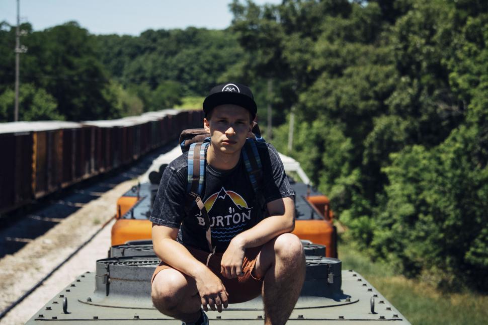 Free Image of Young man sitting on train car 