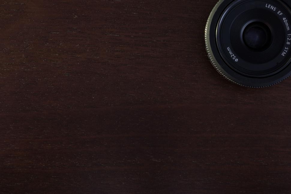 Free Image of Camera lens on a dark wooden background 
