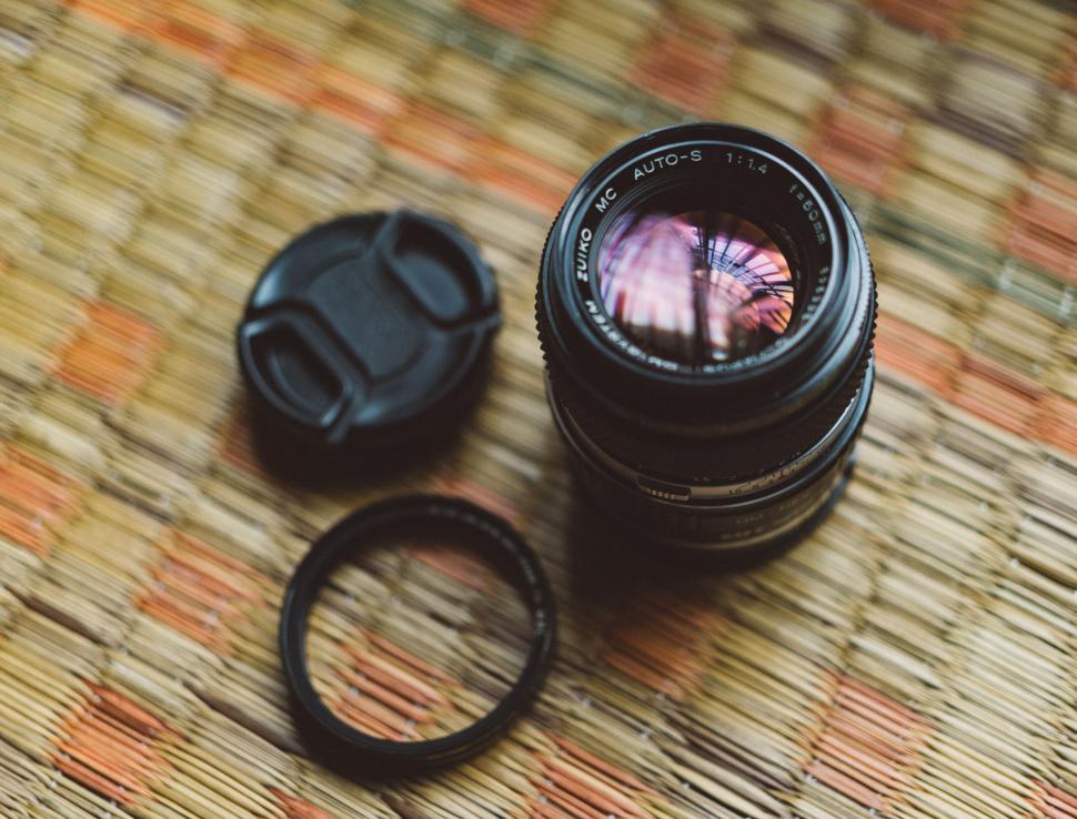 Free Image of Close-up of vintage camera lens on straw mat 