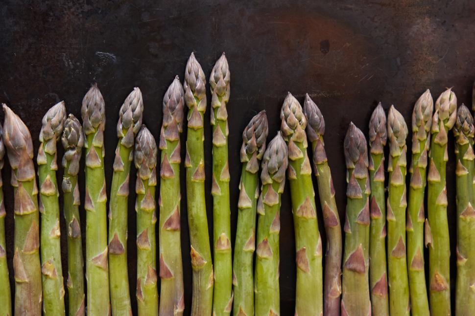 Free Image of Asparagus spears neatly arranged on dark surface 